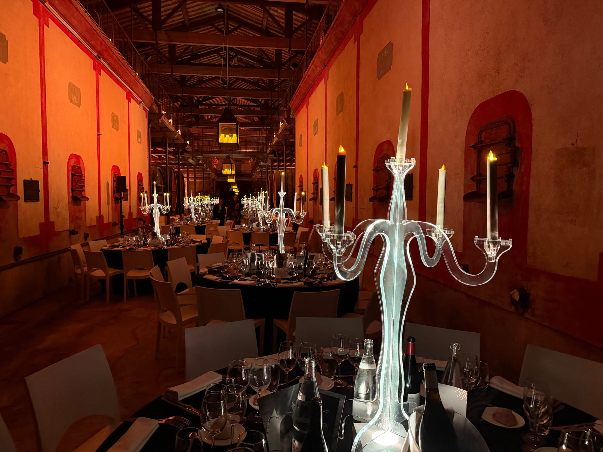 Tables dressées avec chandeliers dans une cave pour la soirée Tout Faire organisée par Liveworks